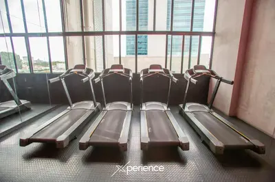 a row of treadmills in a gym with windows at Serenity at 12, City Views and Wonderland Vibes! in Hatillo