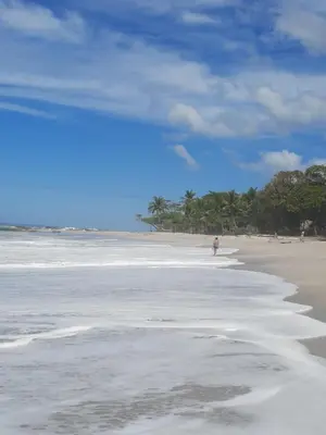 a person standing on a beach with the water at Casa Mor - Surfhouse - 2 min from the beach in Santa Teresa Beach