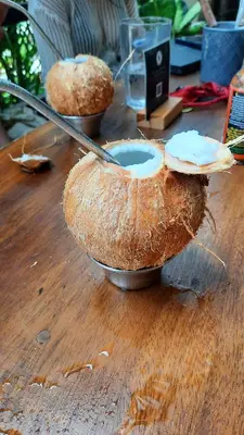 two halves of a coconut sitting on a wooden table at Casa Mor - Surfhouse - 2 min from the beach in Santa Teresa Beach