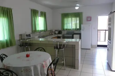 a kitchen with a table and a kitchen with green curtains at Apto D Laidman y Raabe SRL in Mercedes