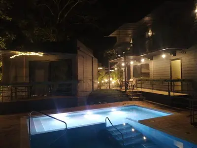 a swimming pool in front of a house at night at Hotel Evasión in Ojochal