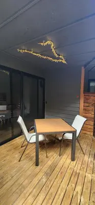 a table and two white chairs on a wooden floor at Hotel Evasión in Ojochal