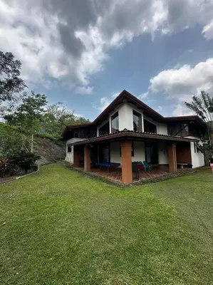 a house with a green lawn in front of it at Casita en la finca Los Bambú in Jaris
