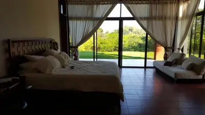 a bedroom with a bed and a couch and windows at Casita en la finca Los Bambú in Jaris