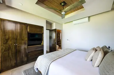 a bedroom with a white bed and a television at Beachfront Villa, Private Pool & Daily Breakfast in Potrero