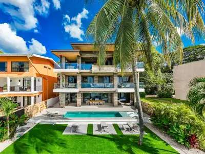 an exterior view of a house with a swimming pool and a palm tree at Beachfront Villa, Private Pool & Daily Breakfast in Potrero