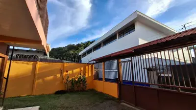 a yellow and white house with a fence at Apartamentos Quepos Malichita Studio in Quepos