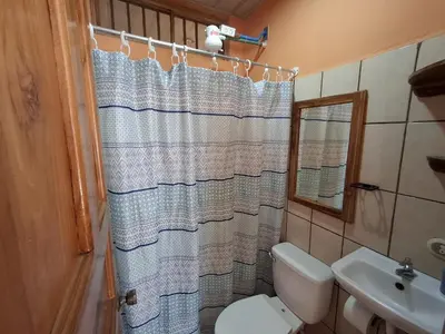 a bathroom with a toilet and a shower curtain at Apartamentos Quepos Malichita Studio in Quepos