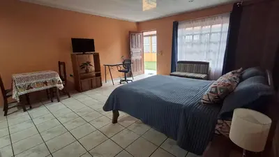 a bedroom with a bed and a television in it at Apartamentos Quepos Malichita Studio in Quepos