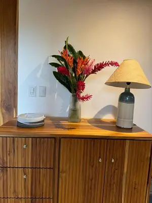 a table with a lamp and a vase with flowers on it at Casa Rucca in Uvita