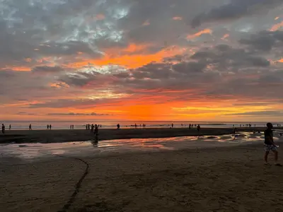 a group of people walking on the beach at sunset at Casa Rucca in Uvita