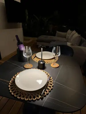 a table with two plates and wine glasses on it at Casa Rucca in Uvita
