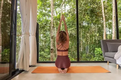 a woman is doing yoga in a room with a window at Pandanus Lodge & Retreats Bungalow Strelizia in San Ramón