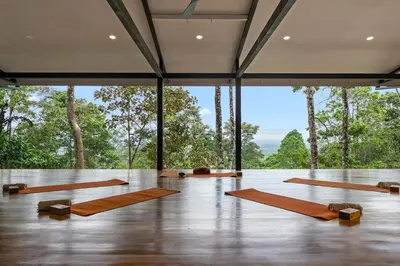 a yoga class in a room with large windows at Pandanus Lodge & Retreats Bungalow Strelizia in San Ramón