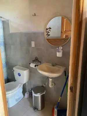 a bathroom with a toilet and a sink and a mirror at Nosara Hemp House in Nosara
