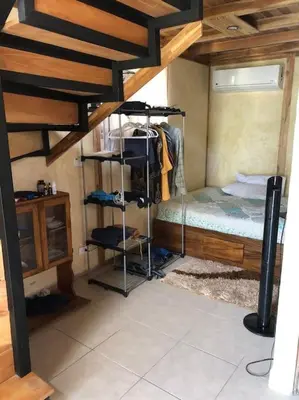 a bedroom with a bunk bed and a room with a staircase at Nosara Hemp House in Nosara