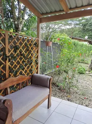 a wooden bench sitting on a porch with a garden at Nosara Hemp House in Nosara
