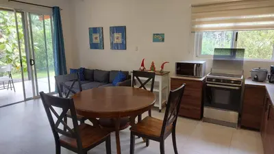 a kitchen and living room with a table and chairs at Villas Pura Vida - Guapinol in Río Negro