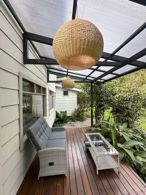 a patio with a chandelier and chairs on a deck at Refugio Monteverde house, privacy & ocean view! in Monteverde Costa Rica