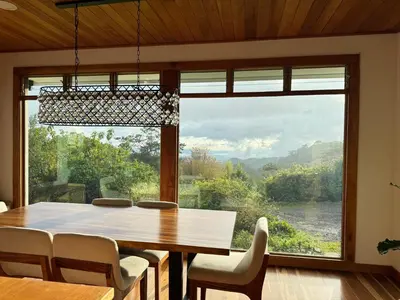a dining room with a table and a large window at Refugio Monteverde house, privacy & ocean view! in Monteverde Costa Rica