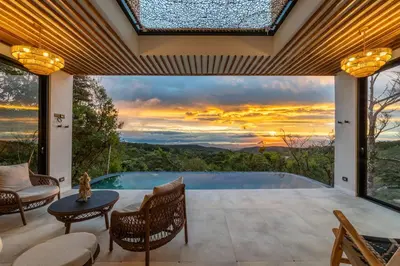 a patio with a pool and a table and chairs at Luxury villa on the Cloud Forest Infinity Pool in Monteverde Costa Rica