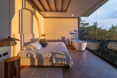 a bedroom with a tub and a bed and a window at Luxury villa on the Cloud Forest Infinity Pool in Monteverde Costa Rica