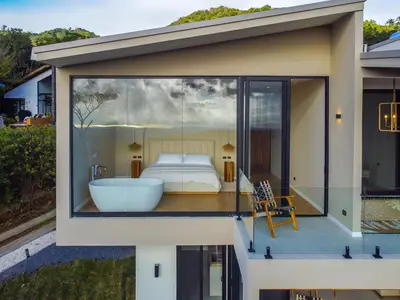a bedroom with a tub and a bed in a window at Luxury villa on the Cloud Forest Infinity Pool in Monteverde Costa Rica