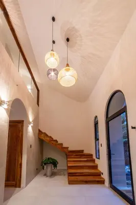 a staircase in a house with two chandeliers at Luxury villa on the Cloud Forest Infinity Pool in Monteverde Costa Rica