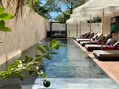 a swimming pool with lounge chairs in a resort at Blooma Boutique Hotel in Santa Teresa Beach