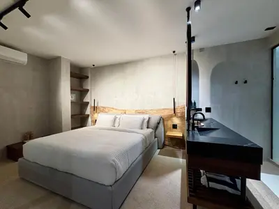 a bedroom with a large bed and a sink at Blooma Boutique Hotel in Santa Teresa Beach