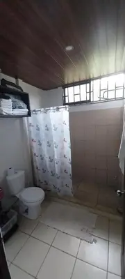 a bathroom with a toilet and a shower curtain at La dulce Casita in Uvita