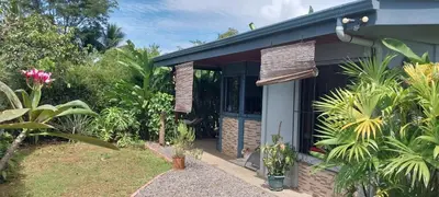 a house with a door open in a garden at La dulce Casita in Uvita
