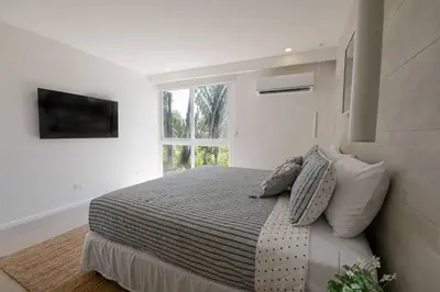 a bedroom with a bed with pillows and a window at Villa Calula in Playa Hermosa