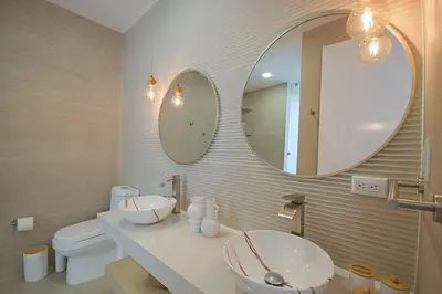 a bathroom with two mirrors and a sink and a toilet at Villa Calula in Playa Hermosa