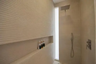 a bathroom with a shower with bottles of wine at Villa Calula in Playa Hermosa