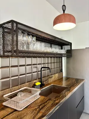 a kitchen counter with a sink and a shelf at Desiree Luxury Apartamentos in Santa Teresa Beach