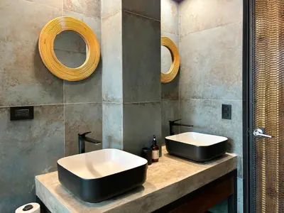 a bathroom with two sinks and two mirrors at Desiree Luxury Apartamentos in Santa Teresa Beach