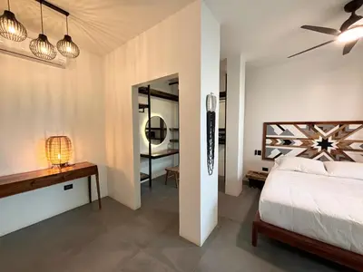 a bedroom with a bed and a desk and a mirror at Desiree Luxury Apartamentos in Santa Teresa Beach