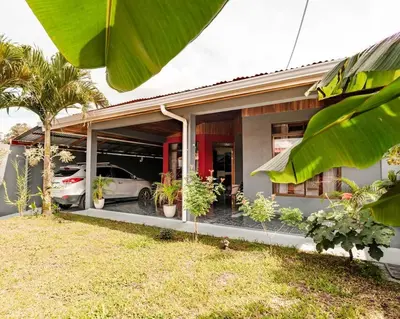 a house with a car parked inside of it at Gaby's Home In Downtown La Fortuna in Fortuna