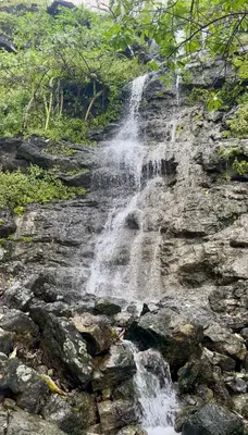a waterfall on the side of a rocky cliff at Cima Del Mar in Sámara