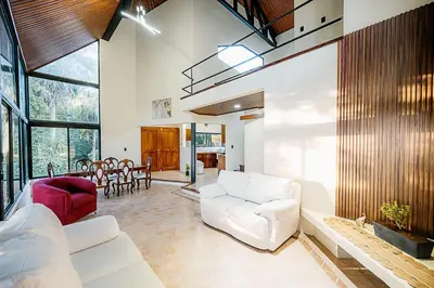 a living room with a white couch and a red chair at Arenal Summit in Nuevo Arenal