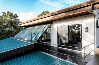 a swimming pool on the side of a house at Arenal Summit in Nuevo Arenal