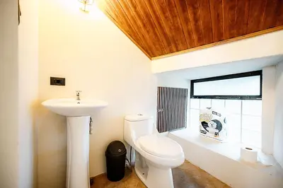a bathroom with a toilet and a sink at Arenal Summit in Nuevo Arenal