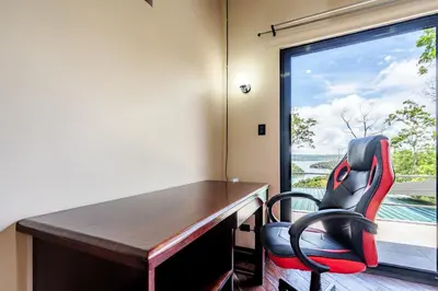 a desk and chairs in a room with a window at Arenal Summit in Nuevo Arenal