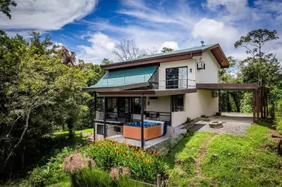 a house with a lot of windows and a yard at Arenal Summit in Nuevo Arenal
