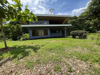 a house with a green yard in front of it at Hospedaje Santiago in Sarapiquí