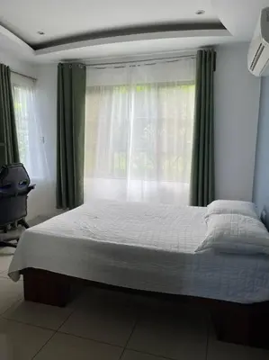 a bedroom with a large bed with a window at Hospedaje Santiago in Sarapiquí