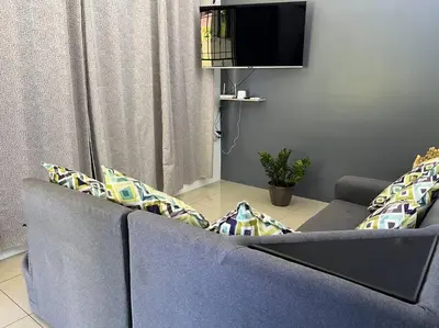 a living room with a blue couch and a tv at Hospedaje Santiago in Sarapiquí
