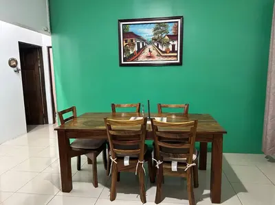 a wooden table with four chairs and a blue wall at Hospedaje Santiago in Sarapiquí