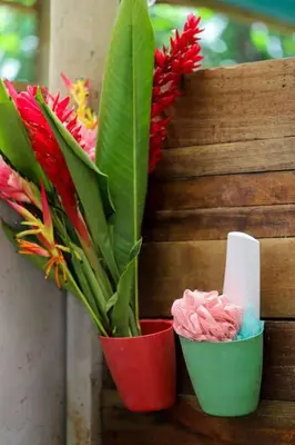 two red cups with flowers in them and a candle at Preciosa Cabaña de Montaña in Turrialba